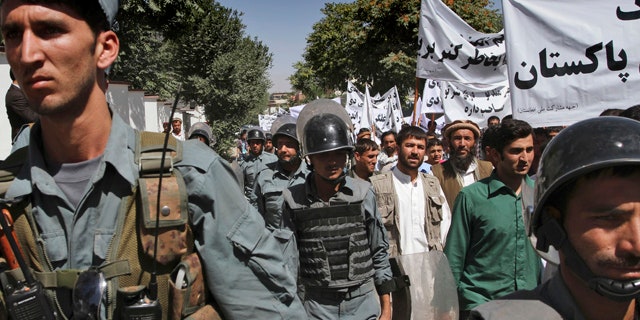 July 2: Afghan policemen escort protestors during an anti-Pakistan demonstration in Kabul, Afghanistan.