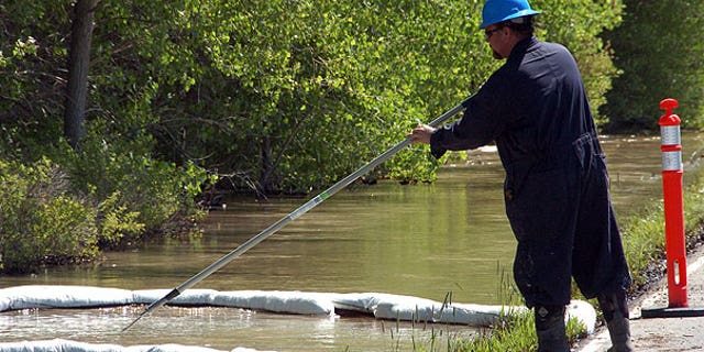 July 2: A contractor for ExxonMobil tends to an oil containment boom along the Yellowstone River near Laurel, Mont., after a pipeline that runs under the river ruptured. The pipeline break was contained early Saturday morning but the spill stretched over dozens of miles.