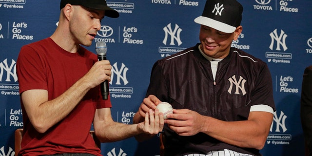 Zack Hample, left, presents New York Yankees Alex Rodriguez with the baseball on which Rodriguez got his 3,000th career hit during a news conference.