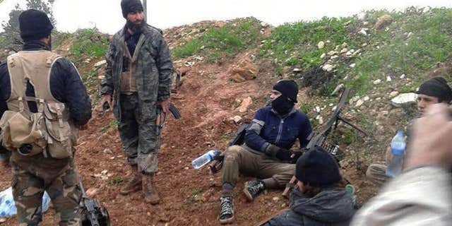 In this Dec. 14, 2014 file photo provided by the anti-government activist group Syrian Observatory for Human Rights shows fighters from the Al Qaeda-linked Nusra Front and other rebel factions resting after clashes with Syrian troops in Wadi Deif in the northwestern province of Idlib, Syria.