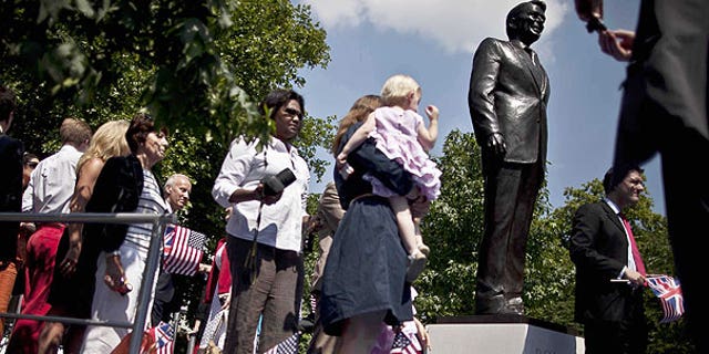 July 4: People take their turn to pose for photographs beside a statue of the late U.S. President Ronald Reagan after its unveiling outside the U.S. embassy in London.