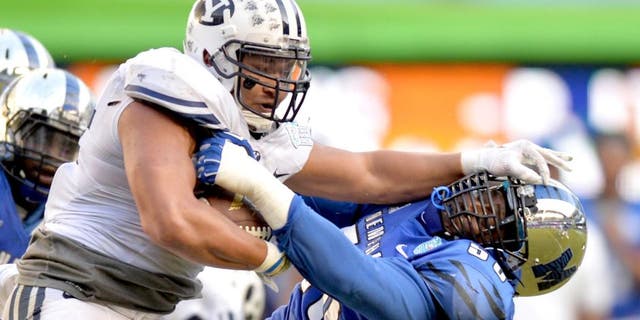 Dec 22, 2014; Miami, FL, USA; Brigham Young Cougars running back Algernon Brown (24) stiff arms Memphis Tigers defensive lineman Terry Redden (56) during the third quarter in the Miami Beach Bowl at Marlins Park. Memphis won 55-48 in a double overtime. Mandatory Credit: Steve Mitchell-USA TODAY Sports