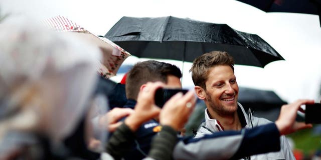 SPIELBERG, AUSTRIA - JULY 03: Romain Grosjean of France and Haas F1 poses for a photo with a fan before the Formula One Grand Prix of Austria at Red Bull Ring on July 3, 2016 in Spielberg, Austria. (Photo by Charles Coates/Getty Images)