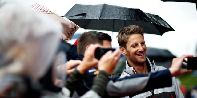 SPIELBERG, AUSTRIA - JULY 03: Romain Grosjean of France and Haas F1 poses for a photo with a fan before the Formula One Grand Prix of Austria at Red Bull Ring on July 3, 2016 in Spielberg, Austria. (Photo by Charles Coates/Getty Images)