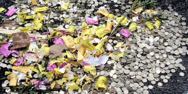 July 5: Heaps of euro coins sit by the roadside after a truck carrying some $2.5 million worth of euros overturned in Foggia, southern Italy, unloading its contents onto the highway and leading motorists to hit the breaks and dig in.