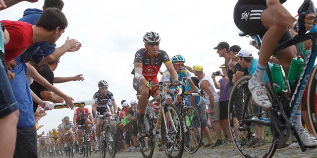 July 6: Lance Armstrong, center, and Alberto Contador of Spain, right of Armstrong, ride on a cobblestone section during the third stage of the Tour de France cycling race over 132.4 miles with start in Wanze, Belgium and finish in Arenberg, France.