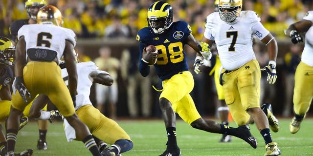 Sep 7, 2013; Ann Arbor, MI, USA; Michigan Wolverines quarterback Devin Gardner (12) runs the ball during the third quarter against the Notre Dame Fighting Irish at Michigan Stadium. Mandatory Credit: Andrew Weber-USA TODAY Sports