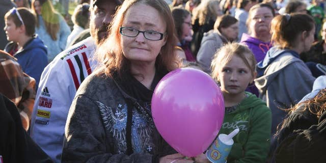 In this Friday, March 25, 2016 photo, Jessica Stewart holds a balloon during a candlelight prayer vigil for her daughter Shaylyn Ammerman at a park in Spencer, Ind. Several hundred people have gathered for the prayer vigil to mourn the loss of the girl found dead days after she went missing. (Jeremy Hogan/Bloomington Herald-Times via AP) MANDATORY CREDIT