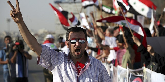 July 7: A man wearing sunglasses painted with the colors of the Syrian national flag gives a v-sign during a rally in support of the Syrian opposition in Amman, Jordan.