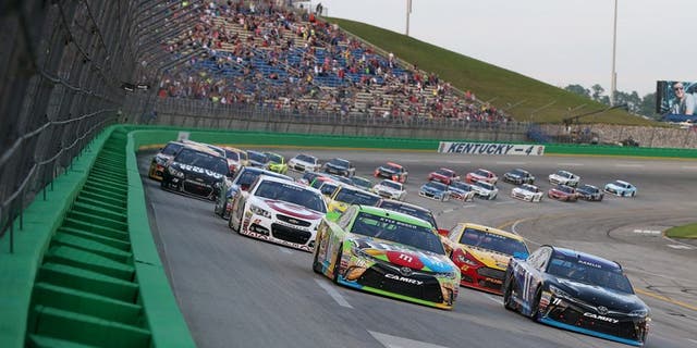 SPARTA, KY - JULY 11: Kyle Busch, driver of the #18 M&amp;M's Crispy Toyota, and Denny Hamlin, driver of the #11 FedEx Office Toyota, lead the field on a restart during the NASCAR Sprint Cup Series Quaker State 400 presented by Advance Auto Parts at Kentucky Speedway on July 11, 2015 in Sparta, Kentucky. (Photo by Brian Lawdermilk/NASCAR via Getty Images)