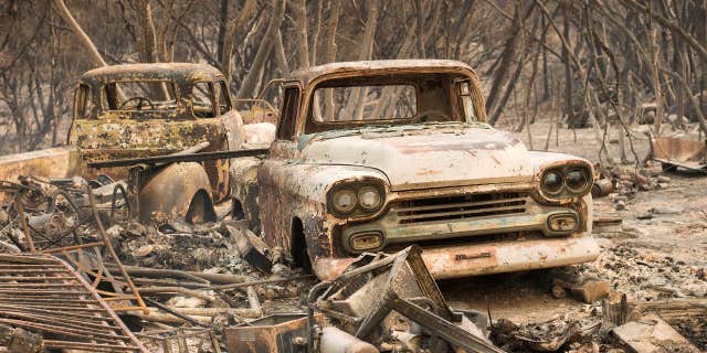 Trucks burned by a wildfire rest in a grove near Oroville, Calif., on Saturday, July 8, 2017.