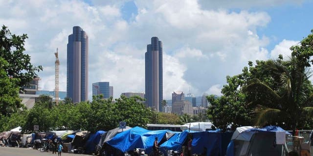 June 30, 2015: People camp out on a sidewalk in the Kakaako neighborhood of Honolulu, Hawaii.