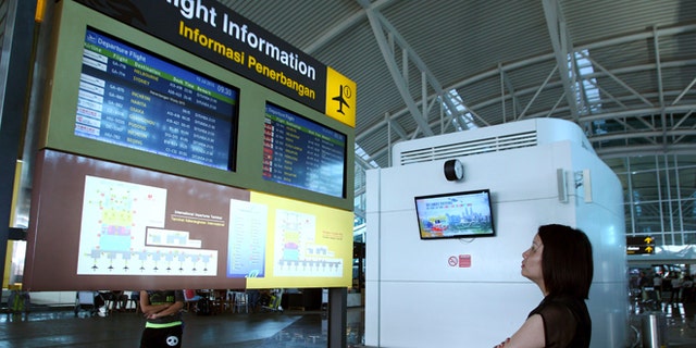 July 10, 2015: A traveler checks the status of flights at Bali's international airport, Indonesia.