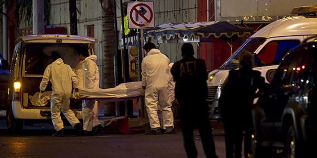 July 8: Forensic workers load a truck with bodies after gunmen stormed into a nightclub in Monterrey, Mexic. At least 17 people were killed in the bar massacre Friday night in the northern Mexican city when riflemen opened fire on the clientele and employees, a state forensic investigator said.