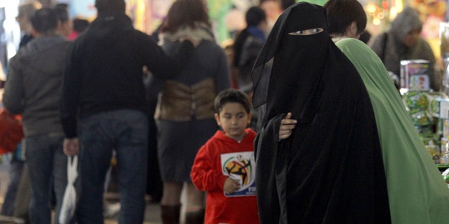 July 10: A Muslim woman wearing a burqa shops at a local market in Sydney.