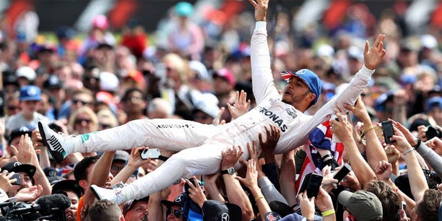 NORTHAMPTON, ENGLAND - JULY 10: Lewis Hamilton of Great Britain and Mercedes GP celebrates his win by crowdsurfing with the fans during the Formula One Grand Prix of Great Britain at Silverstone on July 10, 2016 in Northampton, England. (Photo by Mark Thompson/Getty Images)