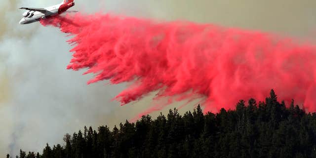 July 9, 2016: A trail of slurry is deposited by a bomber while fighting the Cold Springs Nederland fire in Colorado.