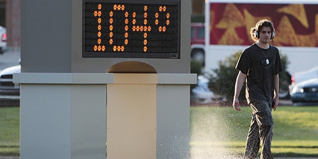 July 11: An unidentified pedestrian walks past a time and temperature sign in Lawrence, Kan.
