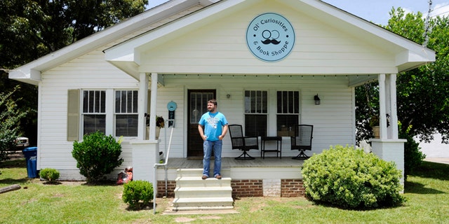 July 8, 2015: Spencer Madrie poses outside his store, Ol' Curiosities & Book Shoppe, in Monroeville, Ala.