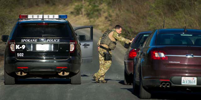 FILE - In this Thursday, April 7, 2016, file photo, officials stop vehicles as they search in Spokane Valley, Wash., for escaped mental patient Anthony Garver.