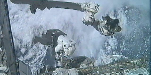 July 12: In an image made from video, astronaut Ronald Garan Jr. dangles outside the International Space Station during the last spacewalk of NASA's space shuttle era, with fellow astronaut Michael Fossum (not shown).