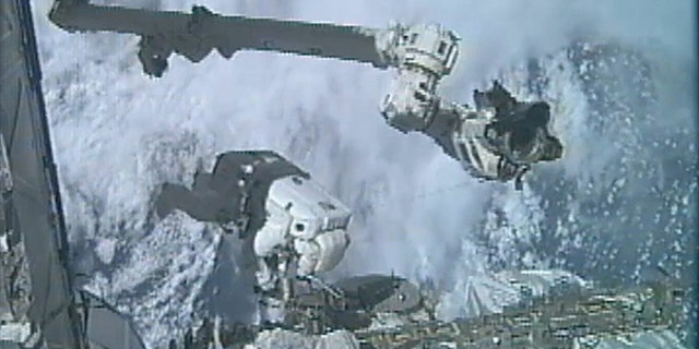 July 12: In an image made from video, astronaut Ronald Garan Jr. dangles outside the International Space Station during the last spacewalk of NASA's space shuttle era, with fellow astronaut Michael Fossum (not shown).