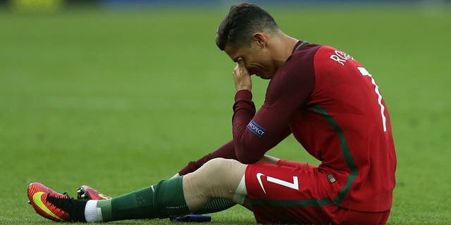 PARIS, FRANCE - JULY 10: Cristiano Ronaldo of Portugal lies injured during the UEFA Euro 2016 Final match between Portugal and France at Stade de France on July 10, 2016 in Paris, France. (Photo by Chris Brunskill Ltd/Getty Images)