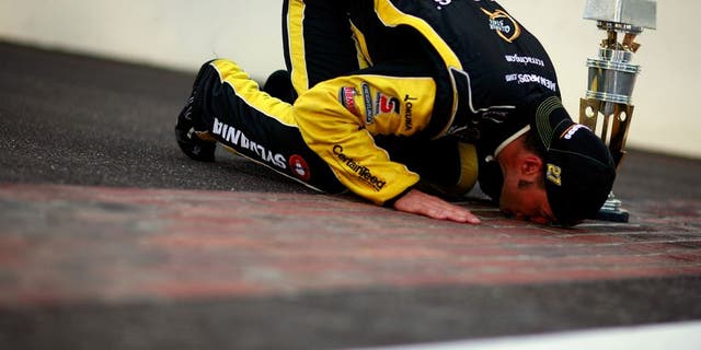 INDIANAPOLIS, IN - JULY 31: Paul Menard, driver of the #27 NIBCO/Menards Chevrolet, poses as he kisses the bricks after winning the NASCAR Sprint Cup Series Brickyard 400 at Indianapolis Motor Speedway on July 31, 2011 in Indianapolis, Indiana. (Photo by Tom Pennington/Getty Images for NASCAR)