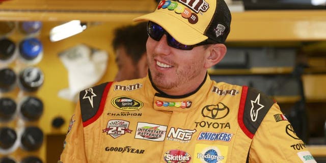 SPARTA, KY - JULY 08: Kyle Busch, driver of the #18 M&M's 75th Anniversary Toyota, stands in the garage area during practice for the NASCAR Sprint Cup Series Quaker State 400 at Kentucky Speedway on July 8, 2016 in Sparta, Kentucky. (Photo by Matt Sullivan/Getty Images)