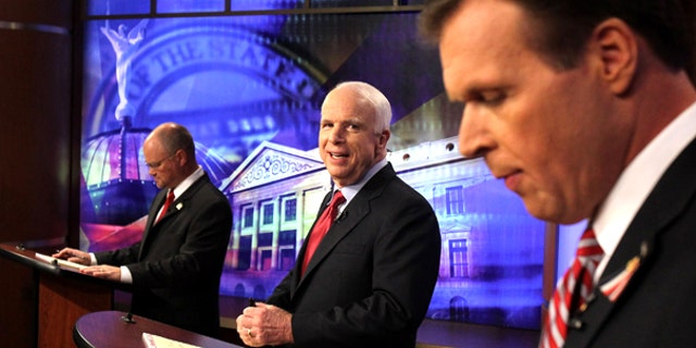 July 16: Sen. John McCain, center, looks at former congressman J.D. Hayworth, right, as political newcomer Jim Deakin checks his notes at the first Arizona Senate Republican debate in Phoenix.