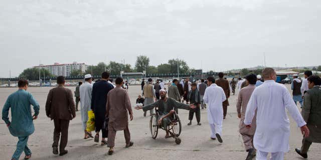 July 17, 2015: An Afghan begger, center, asks for money after Eid al-Fitr prayers in Eid Gah mosque in Kabul, Afghanistan.
