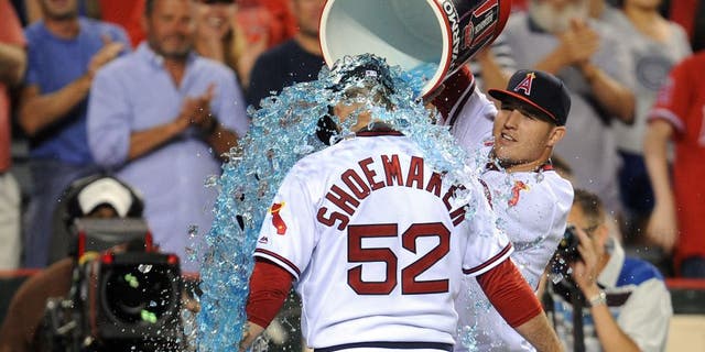 July 16, 2016; Anaheim, CA, USA; Los Angeles Angels center fielder Mike Trout (27) pours sport drink on starting pitcher Matt Shoemaker (52) in celebration of his 1-0 complete game victory against the Chicago White Sox at Angel Stadium of Anaheim. Mandatory Credit: Gary A. Vasquez-USA TODAY Sports