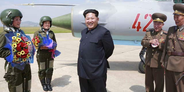June 22, 2016: North Korean leader Kim Jong Un smiles as he attends a flight training session by female fighter pilots Jo Kum Hyang and Rim Sol in this undated photo released by North Korea's Korean Central News Agency.