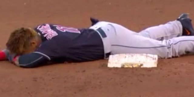 The Indians' Jose Ramirez slides face-first into second base.