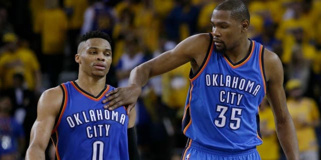 Oklahoma City Thunder's Kevin Durant (35) pats teammate Russell Westbrook (0) on the shoulder as they take a lead over the Golden State Warriors during the second half in Game 1 of the NBA basketball Western Conference finals Monday, May 16, 2016, in Oakland, Calif. Oklahoma City won 108-102. (AP Photo/Marcio Jose Sanchez)