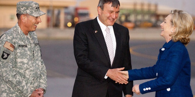 July 19: U.S. Ambassador to Afghanistan Karl Eikenberry, center, and General David Petraeus, left, greet Secretary of State Hillary Clinton as she steps off her plane at Kabul International Airport.