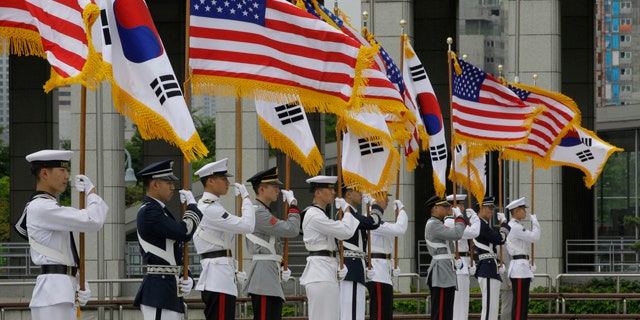 South Korean honor guard soldiers hold American and South Korean national flags during a rehearsal for the welcoming ceremony of U.S. Secretary of State Hillary Rodham Clinton and Defense Secretary Robert Gates in Seoul, South Korea, Tuesday, July 20, 2010. Gates, who arrived on Monday, will be joined by Clinton on Wednesday for high-profile security talks with their South Korean colleagues, a meeting meant to underscore Washington's firm alliance with Seoul as the two nations plan military exercises in a message of deterrence to North Korea. (AP Photo/ Lee Jin-man)