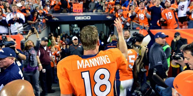 Dec 2 2012; Denver, CO, USA; Denver Broncos quarterback Peyton Manning (18) tosses a piece of equipment to the fans following the win over the Tampa Bay Buccaneers at Sports Authority Field. The Broncos defeated the Buccaneers 31-23. Mandatory Credit: Ron Chenoy-USA TODAY Sports