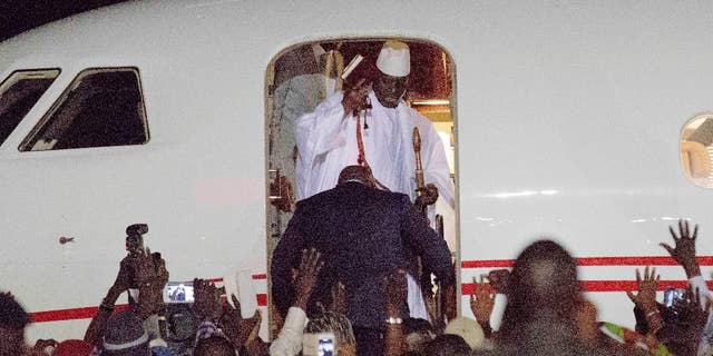 FILE - In this file photo dated Saturday Jan. 21, 2017, Gambia's defeated leader Yahya Jammeh, top wearing white, waves to supporters as he goes into exile from Gambia's capital Banjul airport. Jammeh fiercely denounced homosexuality and warned gay people to leave the country with threats to "cut of the head" of any who remained, so Jammeh's departure "is a great relief for the population, and especially the LGBT population who were often martyred under his rule," said Lambert Lamba, a leading gay rights activist in Cameroon. (AP Photo/Jerome Delay, FILE)