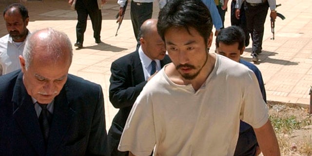 April 17, 2004: Japanese freelance journalist Jumpei Yasuda, right, is escorted after being released at Umm Al-Qura mosque in Baghdad, Iraq.  Worries are growing about the whereabouts of the freelance Japanese journalist, last heard from late June, 2015,  in Syria.