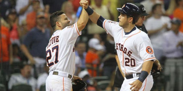 Houston Astros' Preston Tucker is greeted at the plate by Jose Altuve, left, after his two-run home run against the Boston Red Sox during the fifth inning of a baseball game Wednesday, July 22, 2015, in Houston. (AP Photo/Richard Carson)