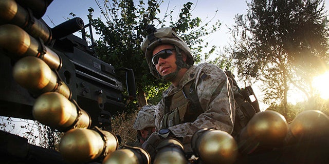 July 21: U.S. Marine Sgt. Adam Wilson mans a Mark 19 heavy gun at a fire position in northern Helmand Province, Afghanistan.