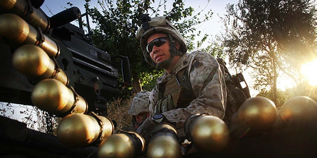July 21: U.S. Marine Sgt. Adam Wilson mans a Mark 19 heavy gun at a fire position in northern Helmand Province, Afghanistan.