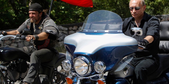Russia's Prime Minister Vladimir Putin, right, rides Harley Davidson Lehman Trike as he arrives for the meeting with Russian and Ukrainian motorbikers at their camp near Sevastopol in Ukraine's Crimea Peninsula, Saturday, July 24, 2010. Russian flag is in the background. Putin has lept on a Harley Davidson and roared into a international biker convention in southern Ukraine. Around 5,000 bikers from Europe and beyond are gathered in Sevastopol for the annual festival on Ukraine's Crimea peninsula. (AP Photo/Sergei Karpukhin, Pool)