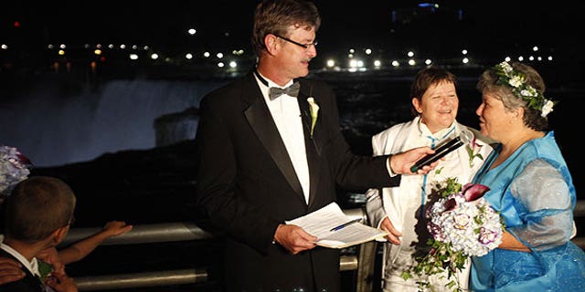 July 24: Kitty Lambert, right, and Cheryle Rudd are married by Niagara Falls Mayor Paul Dyster, left, in Niagara Falls, N.Y.