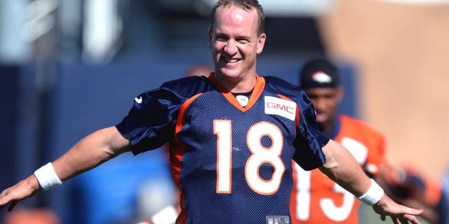 Jul 24, 2014; Dove Valley, CO, USA; Denver Broncos quarterback Peyton Manning (18) warms up during training camp activities at the Broncos training facility. Mandatory Credit: Ron Chenoy-USA TODAY Sports