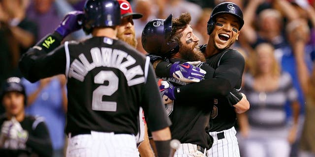 Jul 24, 2015; Denver, CO, USA; Colorado Rockies right fielder Carlos Gonzalez (5) hugs center fielder Charlie Blackmon (19) after his game winning run in the ninth inning against the Cincinnati Reds at Coors Field. Mandatory Credit: Isaiah J. Downing-USA TODAY Sports