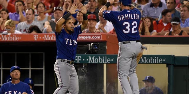 Jul 24, 2015; Anaheim, CA, USA; Texas Rangers left fielder Josh Hamilton (right) celebrates with second baseman Rougned Odor (12) after scoring during the fifth inning against the Los Angeles Angels at Angel Stadium of Anaheim. Mandatory Credit: Kelvin Kuo-USA TODAY Sports