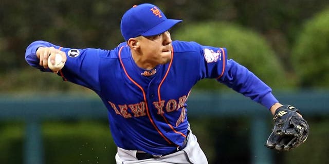 May 29, 2014; Philadelphia, PA, USA; New York Mets shortstop Wilmer Flores (4) attempts to throw out a runner in the second inning of a game against the Philadelphia Phillies at Citizens Bank Park. Mandatory Credit: Bill Streicher-USA TODAY Sports