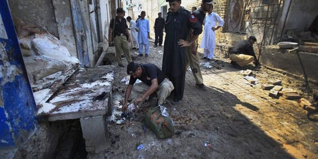 July 26: Policemen collect evidence at the site of a homicide bomb attack in Pabbi town, 26 km (16 miles) east of the provincial capital, Peshawar (Reuters).